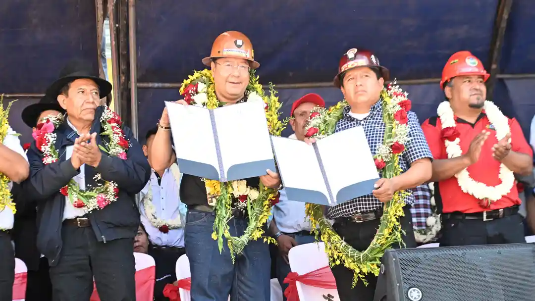 El presidente Luis Arce entrega los decretos promulgadas al dirigente de la COB, Juan Carlos Huarachi.