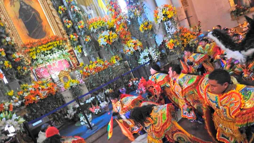 Danzarines del Carnaval de Oruro postrados ante la Virgen de Socavón.