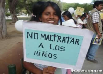 Niña muestra un letrero con el slogan de “No maltratar a los niños”